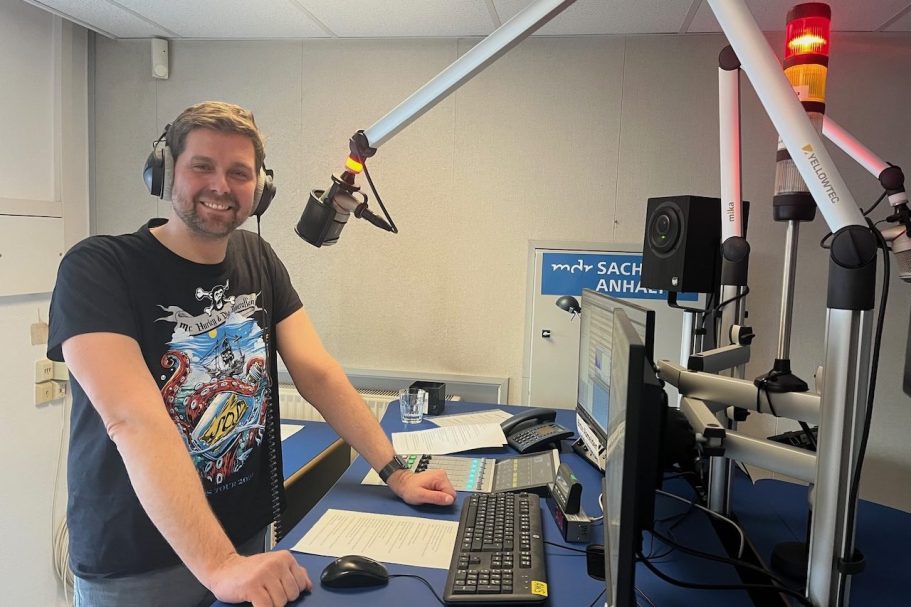 Ein Schreibtisch mit einer Zeitung, einem Tablet und einer Tasse Kaffee.