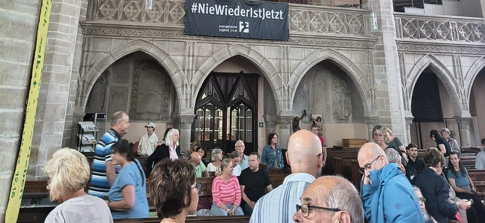 Proben einer Theateraufführung mit Schauspielern und Musiker:innen auf der Bühne.